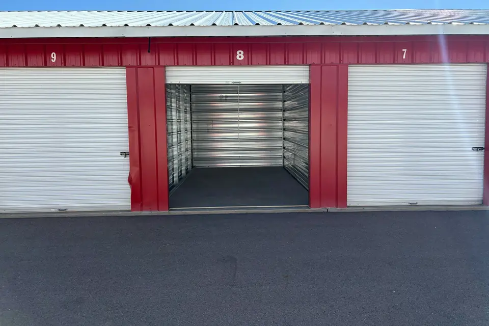 An open storage unit between closed roll-up doors